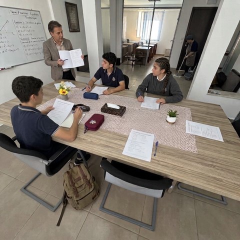 Séance de travail autour d'une table avec un enseignant